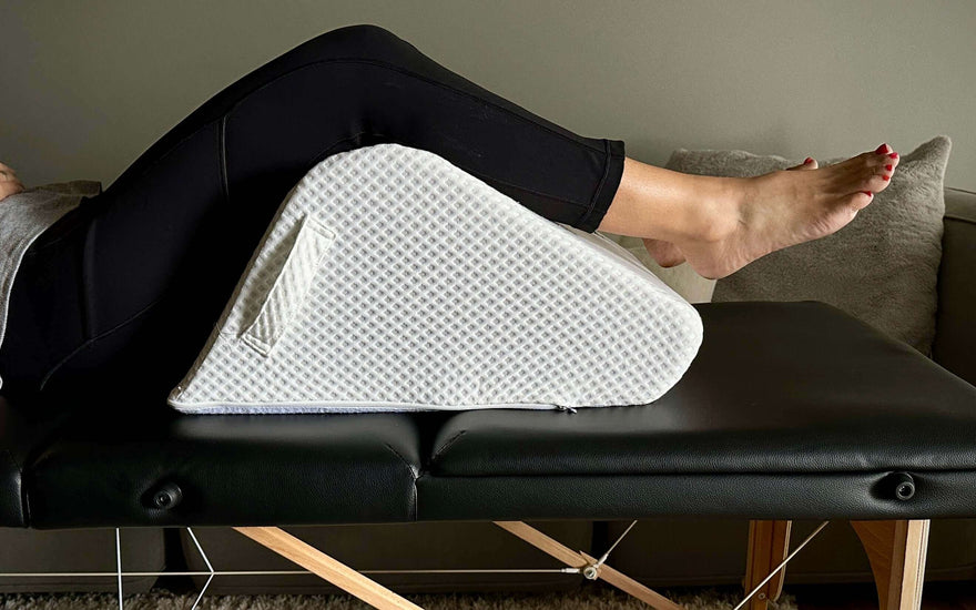 woman resting on massage table using ergonomic leg pillow for balanced sleep positioning