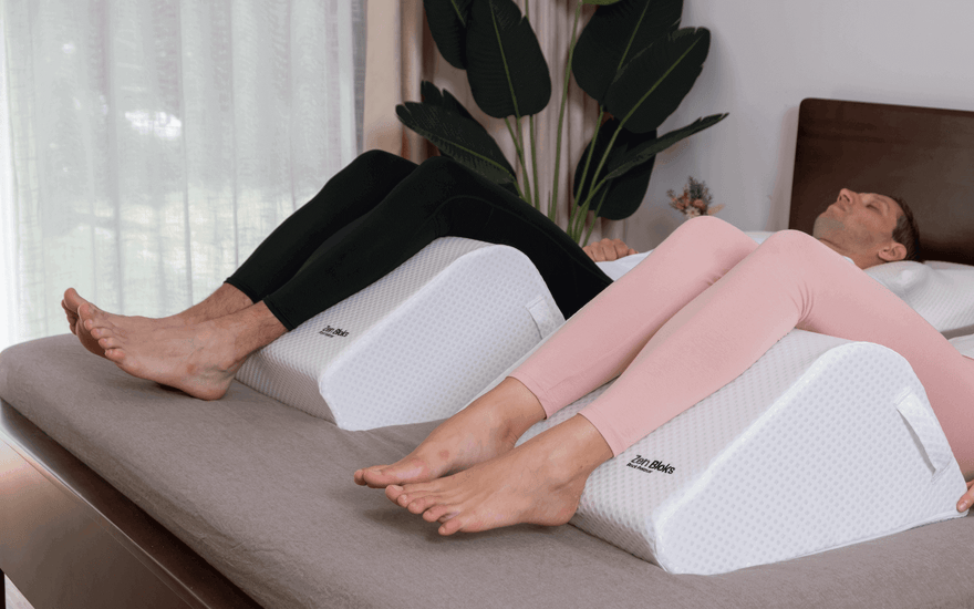 a couple recovering at home in bed using ergonomic leg wedge for balanced elevation comfort