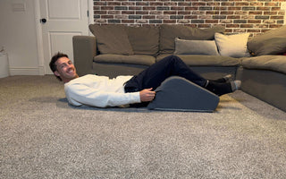 woman relaxing with leg wedge pillow demonstrating everyday elevation comfort