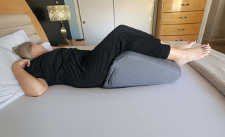woman using leg pillow on the bed for home relaxation and legs elevated
