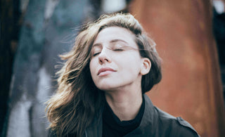 woman practicing mindful breathing on couch for daily relaxation and balance  